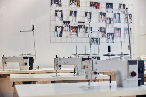 Preview: Table with sewing machine stands in row in light production workshop