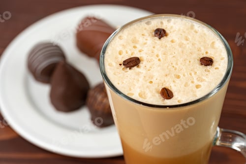 Preview: Cup of coffee and saucer with chocolate sweets on wooden table