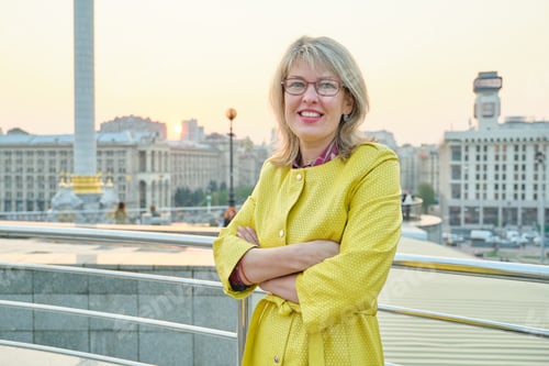 Preview: Outdoor portrait of smiling mature woman with folded hands