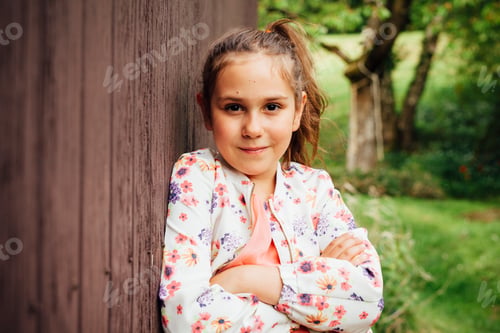 Preview: Portrait of smiling girl leaning against wooden wall