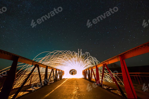 Preview: Light painting art concept. Long exposure shot of spinning steel wool in abstract circle