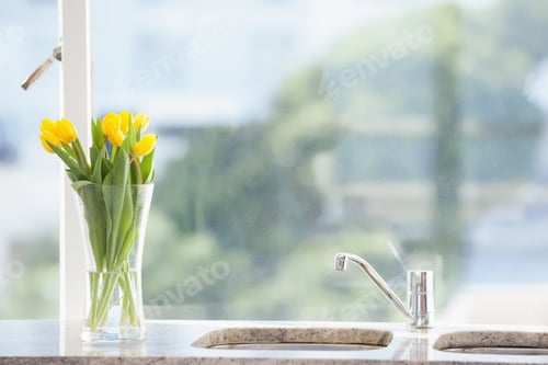 Preview: Yellow flower in a vase on the sink at home in the living room