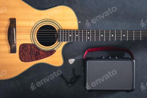 Preview: Acoustic guitar and speaker on a black background, top view.