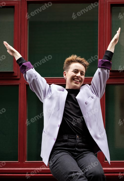 Preview: Happy alternative young female model posing with arms up.