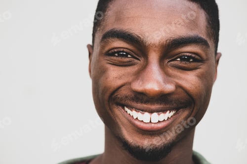 Preview: Close up handsome young African man smiling by white background