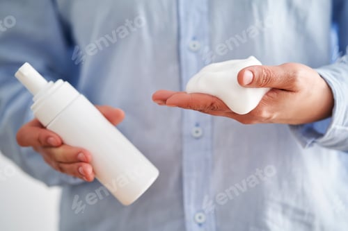 Preview: Hands in a blue shirt hold a savory facial foam demonstrating its texture.