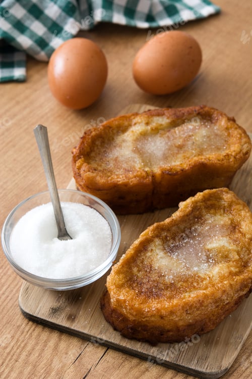 Preview: French toast torrijas with sugar and eggs on wooden table