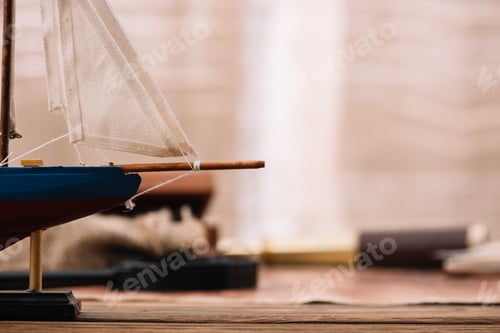 Preview: close up view of blue ship with white sail on brown surface