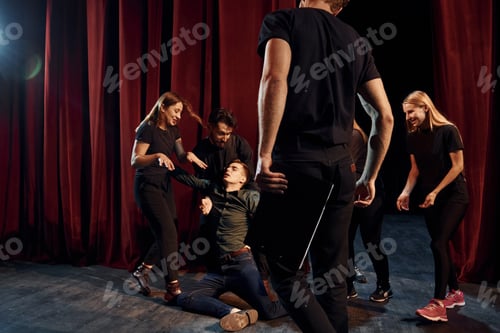 Preview: Fight scene. Group of actors in dark colored clothes on rehearsal in the theater