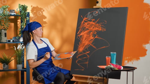 Preview: Portrait of woman painting artwork on canvas with brush
