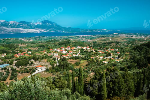 Preview: View of idyllic valley town with red roofs on mediterranean island. Olive groves, cypresses and blue