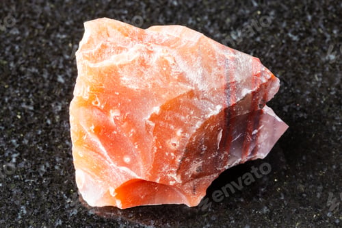 Preview: sample of raw carneol mineral on black granite