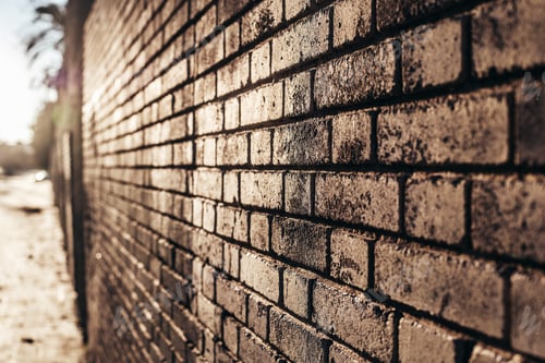 Preview: Brick wall background at sunset with sun rays, stone texture.