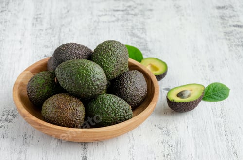 Preview: Fresh ripe avocado with leaves in a wooden plate. Healthy food concept. Top view, copy space.