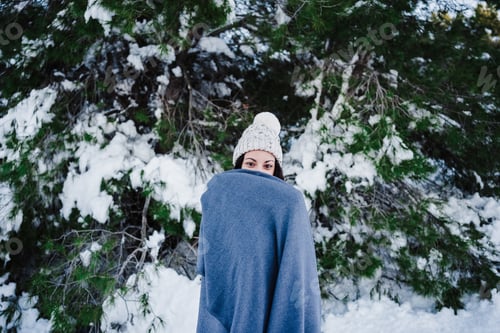 Preview: beautiful woman in snowy mountain covered in blanket. winter season. nature