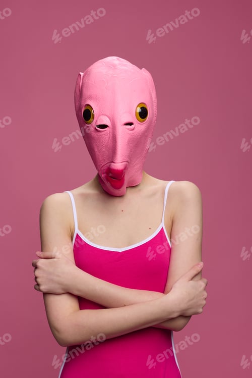 Preview: Conceptual art photo of a sexy woman in a fish mask for Halloween on a pink background