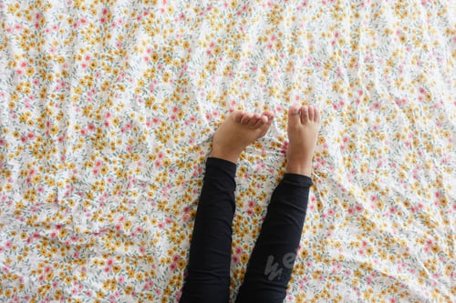 Preview: top view of child girl feet on bed