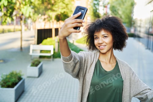 Preview: African woman taking a selfie outdoors