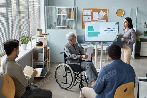 Preview: Mature woman using wheelchair in business meeting