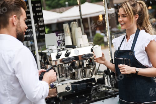 Preview: Beautiful woman barista selling coffee to the customer