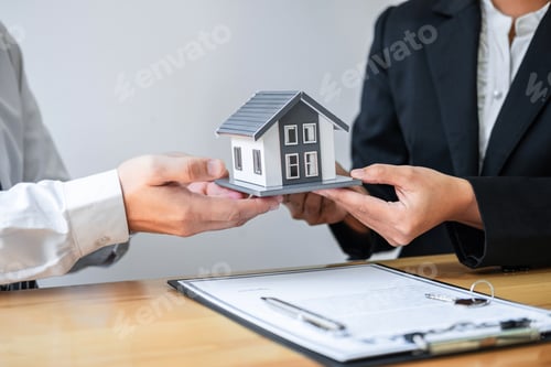 Preview: Estate agent are presenting home loan and giving house to client after discussing and signing