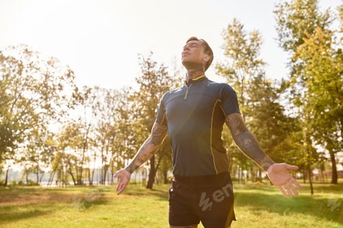 Preview: Handsome young man enjoying a peaceful walk in a sunlit park during early evening