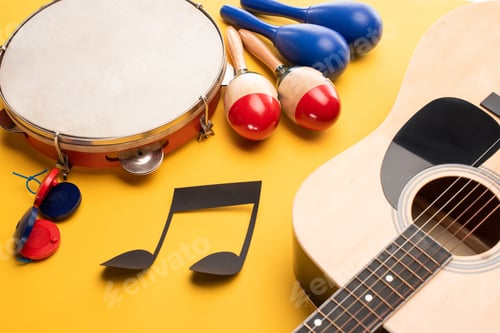 Preview: Musical instruments and paper cut music note on yellow background