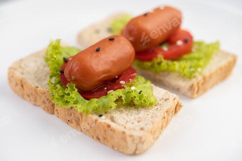 Preview: Sausage with tomatoes, salad and two sets of bread on a white plate.