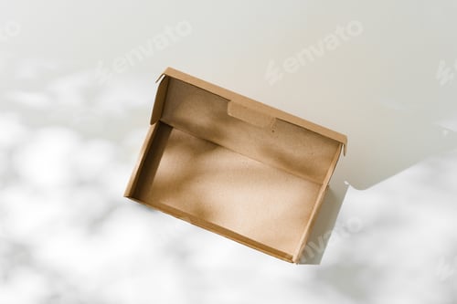 Preview: Open cardboard box on a reflective surface with soft shadows