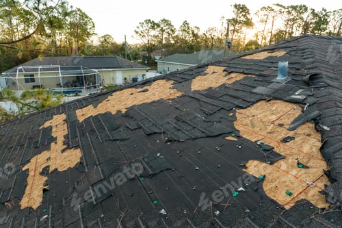 Preview: Ruined rooftop in need of repair. Wind damaged house roof with missing asphalt shingles