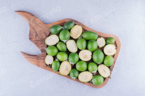 Preview: Tasty feijoas bundled up in a wooden tray on marble background