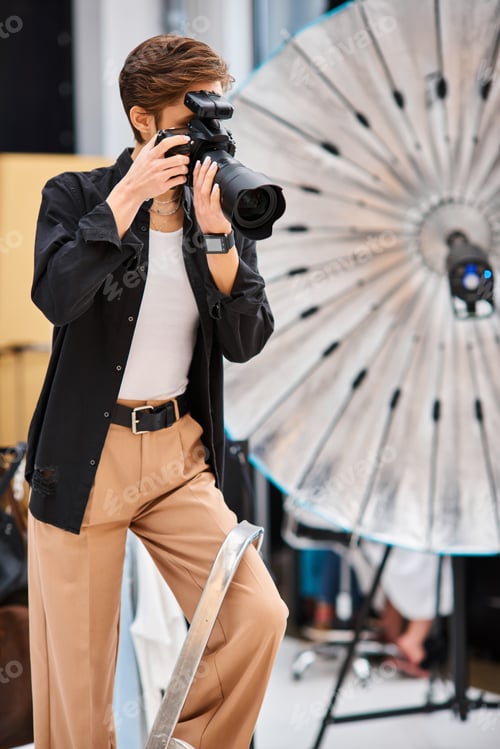 Preview: attractive short haired woman in casual attire taking photos with her modern camera in her studio