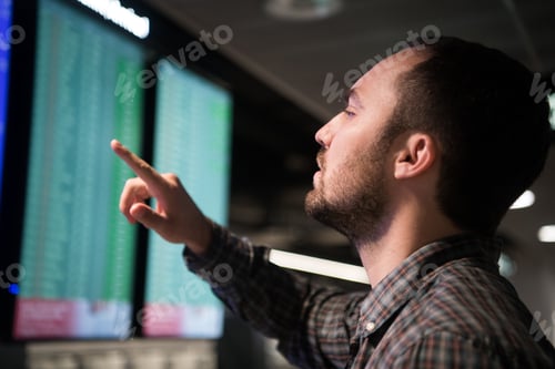 Preview: Man In Front Of Arrivals And Departures Board At The Airport. Travel concept