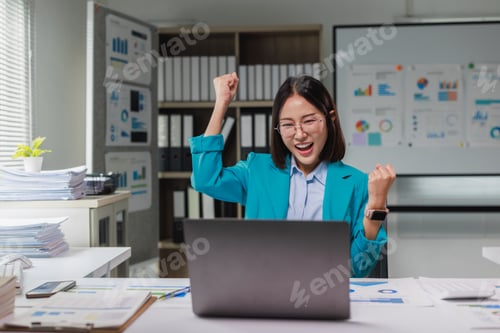 Preview: Asian businesswoman celebrating achievement looking at laptop screen