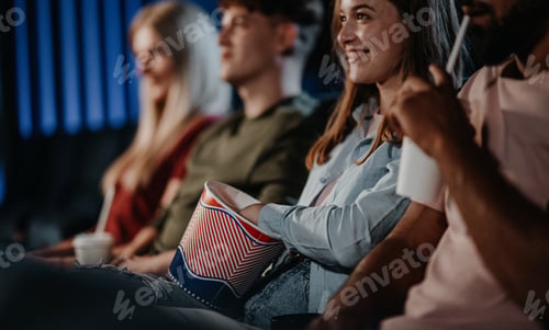 Preview: Unrecognizable cheerful young people sitting in the cinema, watching film