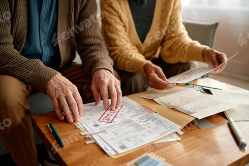 Preview: Senior Couple Reviewing Overdue Invoices and Analyzing Bills Together