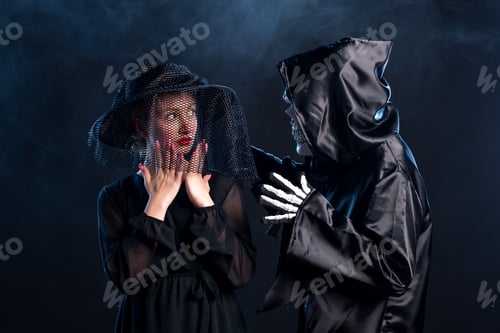 Preview: young woman dressed in all black with lord of death on a dark background funeral grim reaper