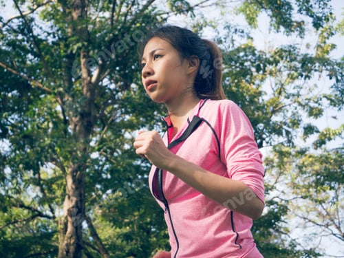Preview: Asian young woman on mark to set ready for jogging exercise to build up her body.