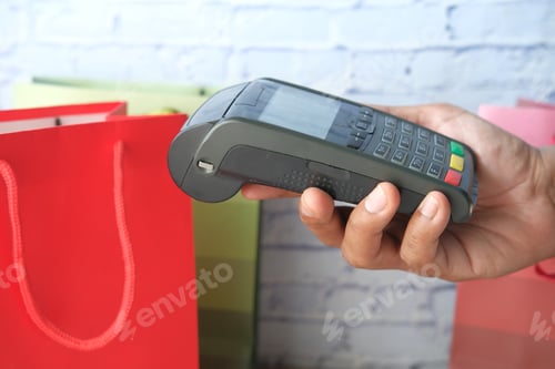 Preview: hand holding pos machine close up .