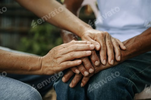 Preview: Hands of the old man and a woman hand on the wood table