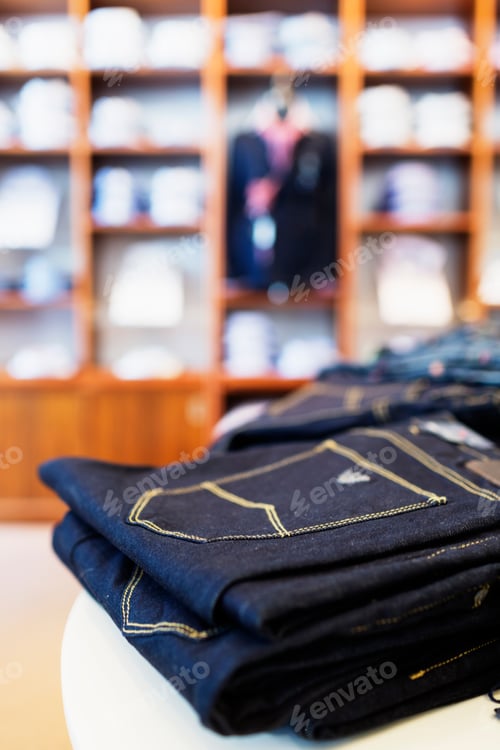 Preview: Close-up of folded jeans on table in clothing store