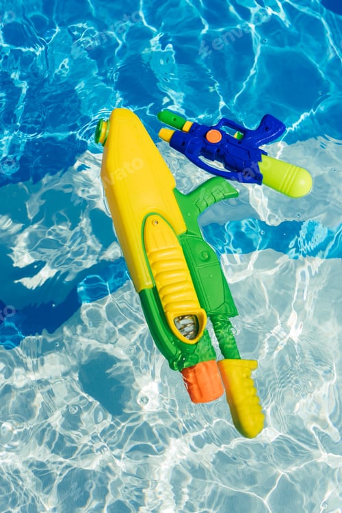 Preview: plastic colorful water guns floating in swimming pool