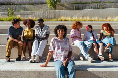 Preview: Multiethnic group of young friends meeting and having fun outdoors