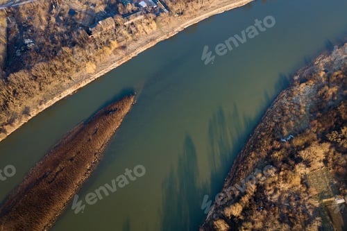 Preview: Aerial top view, countryside panorama of quiet river water and island with dry grass, misty horizon
