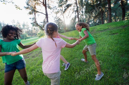 Preview: A group of four girls holding hands and dancing outside.