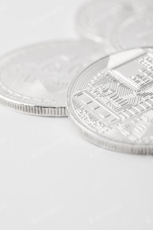Preview: close-up shot of pile of silver bitcoins on white tabletop