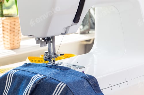 Preview: Sewing machine with striped blue white fabric and thread, home crafting or hobby, horizontal