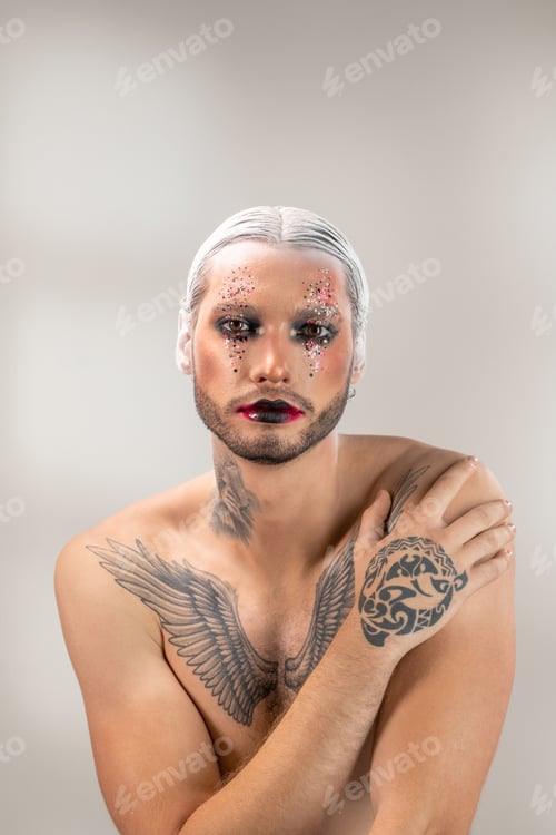 Preview: Young actor of modern theatre with tattoo on chest, neck and hand looking at you