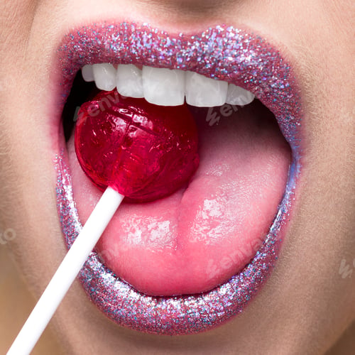 Preview: A closeup of glittering lips tasting a red lollipop