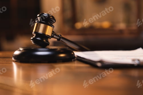 Preview: Judge gavel on the table with blurry books in the background